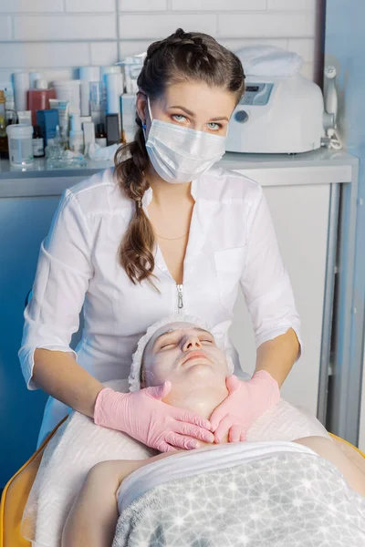 プロの美容師は女性に顔のマッサージを行います. — ストック写真