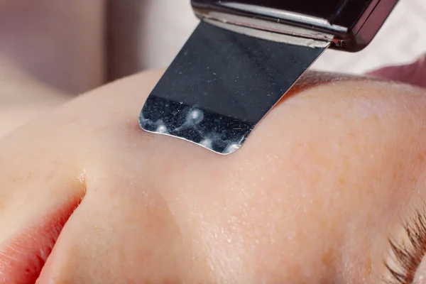 A professional cosmetologist performs an ultrasonic face cleaning procedure for a woman. — Fotografia de Stock