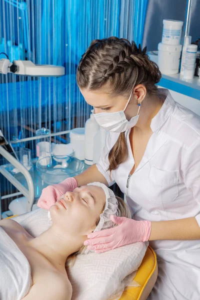 Esteticista profesional limpia una cara de mujer después del procedimiento. —  Fotos de Stock