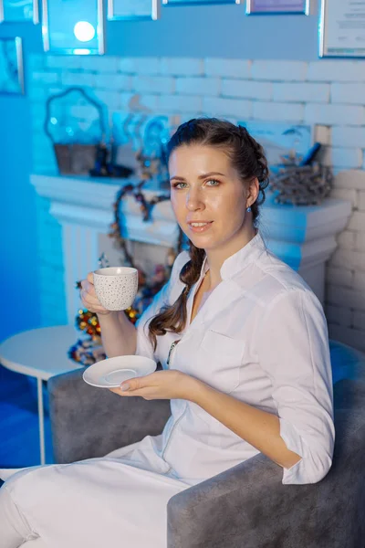 Beautiful young doctor woman with a cup of tea in her hands. — Stockfoto