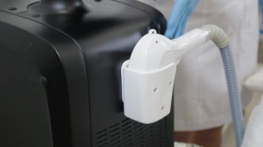 Profesyonel güzellik uzmanı kadın eline lazer kılı almak için lazer alıyor..