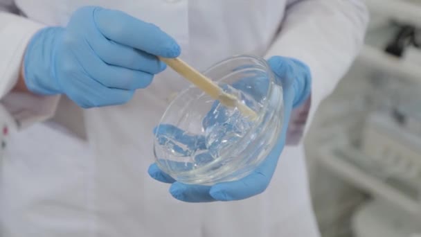 Woman beautician stirring gel for laser depilation. — Stockvideo