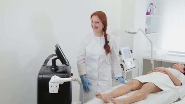 Закрытие рук косметолога в перчатках включает лазерное оборудование перед процедурой, вид сбоку. Концепт центр красоты, медицинская клиника. — стоковое видео