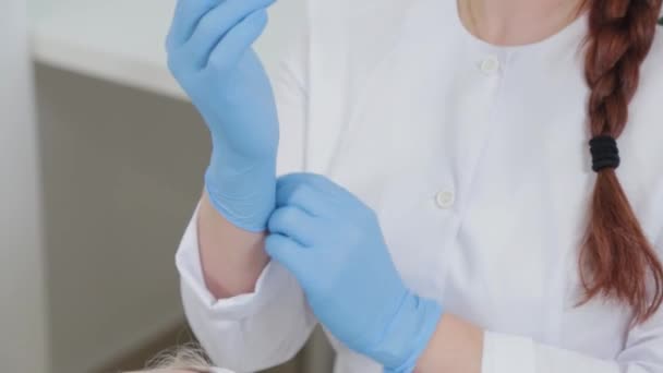 Profi kozmetikus nő felvesz gumikesztyűt. — Stock videók