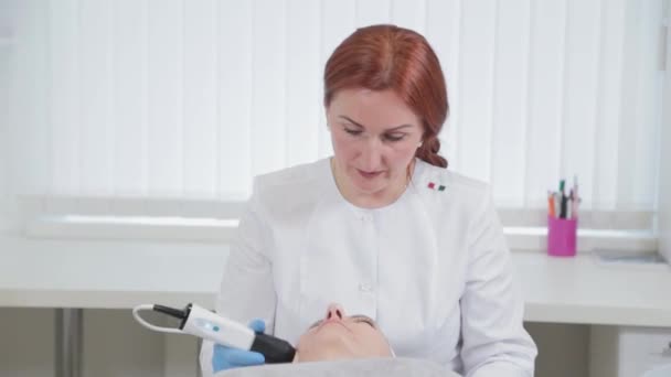 Mujer esteticista profesional haciendo máquina de carboxiterapia en la cara de un cliente. — Vídeos de Stock