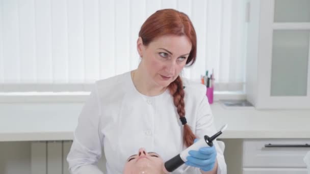 Mujer esteticista profesional haciendo masaje facial con dispositivo de carboxiterapia en el salón de belleza. — Vídeos de Stock