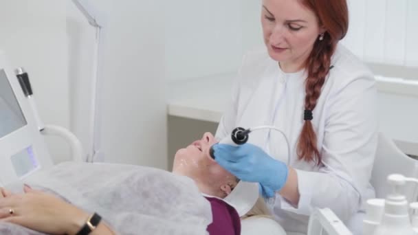 Profesionální kosmetička dělá masáž obličeje s karboxyterapie zařízení v salonu krásy. — Stock video