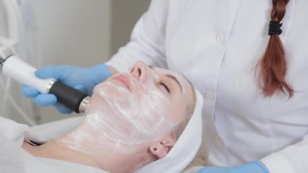 Profesjonalna kosmetyczka robi masaż twarzy z urządzeniem do karboksyterapii w salonie piękności. — Wideo stockowe