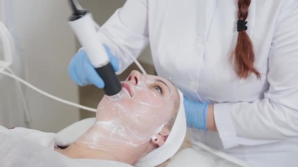 Profesyonel güzellik uzmanı kadın güzellik salonunda karboksiterapi cihazıyla yüz masajı yapıyor.. — Stok video