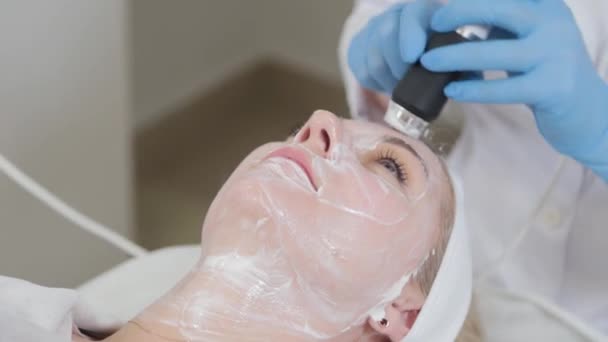 Профессиональная косметолог делает массаж лица с помощью карбоксиотерапевтического аппарата в салоне красоты. — стоковое видео
