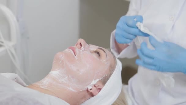 Profesional ahli kecantikan tisu krim off womans wajah. — Stok Video
