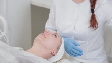 Profesyonel güzellik uzmanı kadın peçetelerle yüz yüze yıkanır..