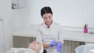 Kadın güzellik uzmanı lastik eldiven takıyor..