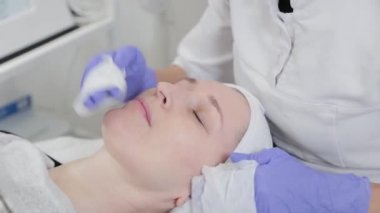 Profesyonel güzellik uzmanı kadın peçetelerle yüz yüze yıkanır..