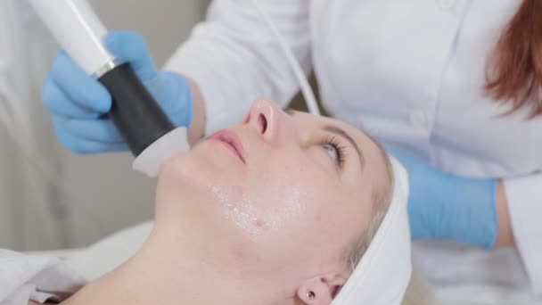 Профессиональный косметолог лечит лицо женщины карбоксиотерапевтическим устройством. — стоковое видео