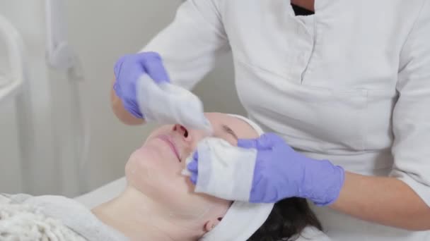 Profesionální kosmetička žena myje tvář ke klientovi s ubrousky. — Stock video
