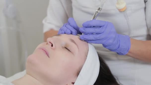 Kvinna kosmetolog utför dermabrasion kosmetisk procedur på kunder ansikte. — Stockvideo
