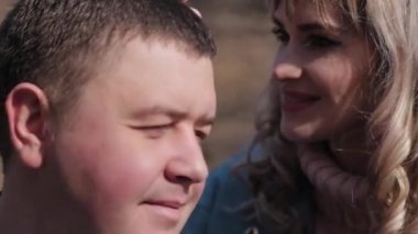 Parkta sevgi dolu bir çift güneşli bir günde korkuluklara sarılıyor..