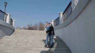 Birbirine aşık bir çift beton bir merdivende sarılıyor..