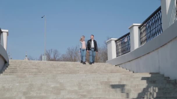 Zamilovaný pár se prochází v parku u nábřeží. — Stock video