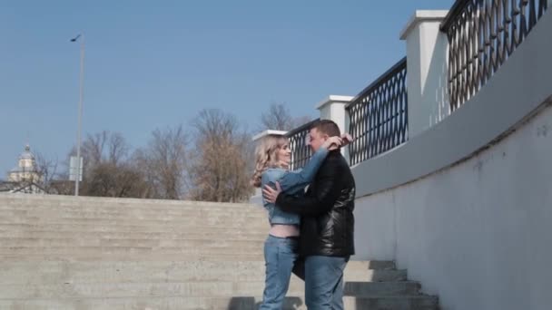 Egy szerelmes pár ölelkezik egy betonlépcsőn.. — Stock videók