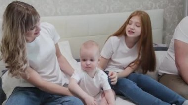Mutlu mutlu bir aile yatağın üstünde.