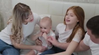 Mutlu mutlu bir aile yatağın üstünde.