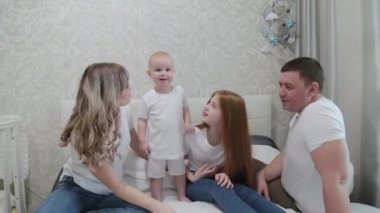 Mutlu mutlu bir aile yatağın üstünde.