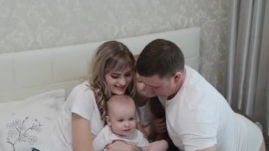 Mutlu mutlu bir aile yatağın üstünde.