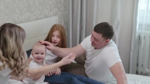 Vrolijk gelukkig gezin op het bed. — Stockvideo