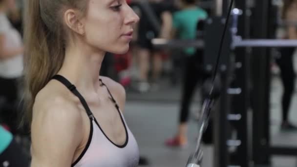 Vacker ung kvinna triceps på blocket i gymmet. — Stockvideo