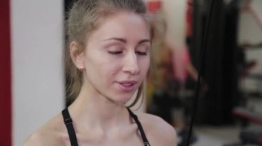 Güzel genç kadın trisepsleri spor salonundaki blokta..