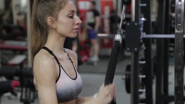 Beautiful young woman triceps on the block in the gym. — Stock Video