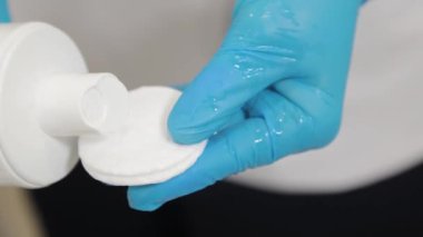 Kadın güzellik uzmanı yüzünü pamukla siliyor..