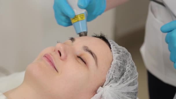 Vrouwelijke cosmetoloog behandelt klanten geconfronteerd met laser. — Stockvideo