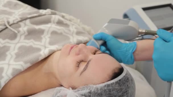 Mujer esteticista haciendo rejuvenecimiento facial con láser. — Vídeo de stock