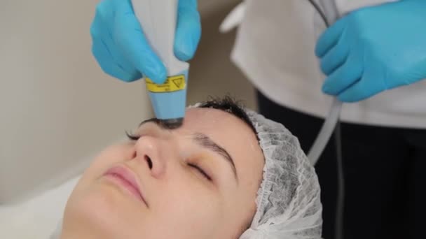 Vrouwelijke cosmetoloog behandelt klanten geconfronteerd met laser. — Stockvideo