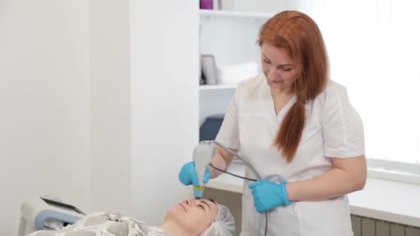 Kosmetikerin behandelt Gesicht von Klienten mit Laser. — Stockvideo