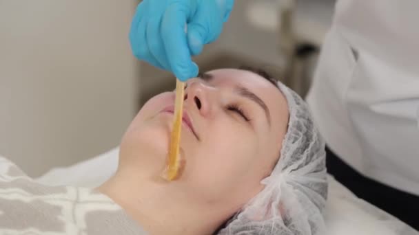 Kvinna kosmetolog applicerar gel på klienter ansikte. — Stockvideo