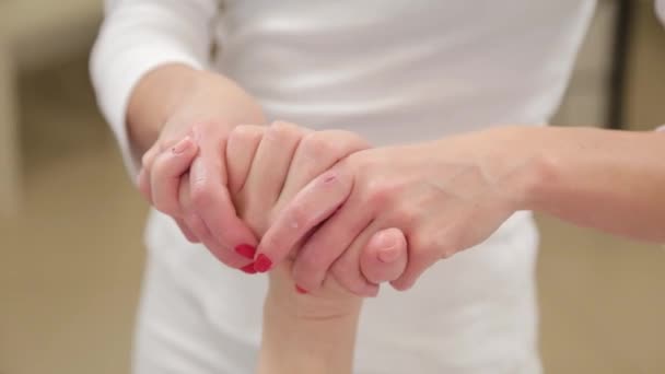 Kobieta kosmetyczka robi masaż dłoni do klienta. — Wideo stockowe