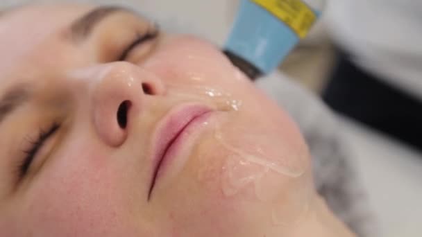 La esteticista trata su cara con un láser. Rejuvenecimiento facial . — Vídeos de Stock