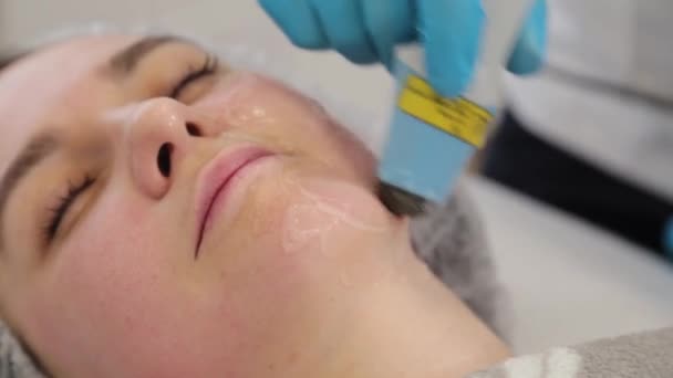 Женщина-косметолог лечит свое лицо лазером. Омоложение лица . — стоковое видео