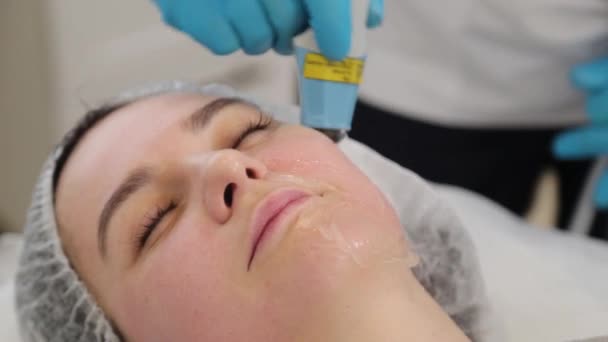 Femme esthéticienne traite son visage avec un laser. Rajeunissement du visage . — Video