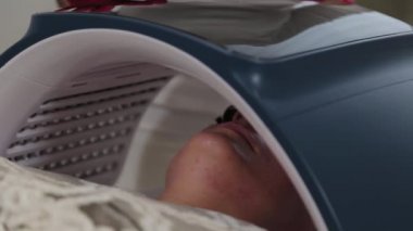 Kadın güzellik uzmanı fotoğraf soymak için cihazı bağlar ve ayarlar.