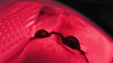 Güzel genç bir kadın, bir güzellik salonunda, bir fotoğrafın altında yatıyor..