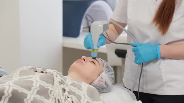 Vrouwelijke cosmetoloog behandelt klanten geconfronteerd met laser. — Stockvideo