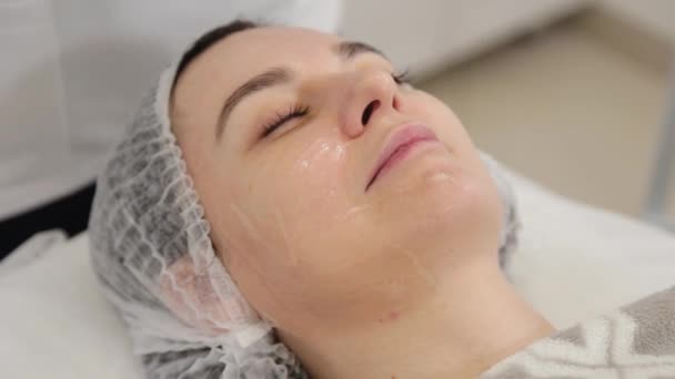 Femme esthéticienne applique gel pour les clients visage. — Video