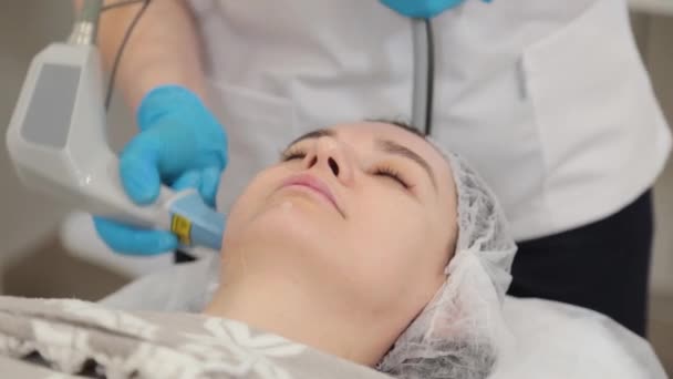 Mujer esteticista haciendo rejuvenecimiento facial con láser. — Vídeos de Stock