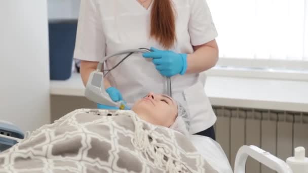 Kvinna kosmetolog gör laser ansiktsföryngring. — Stockvideo
