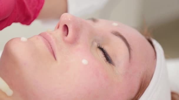 Женщина косметолог капает сыворотку с пипеткой на лице. — стоковое видео